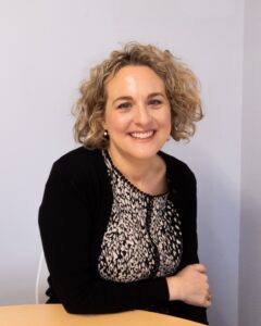 A portrait photograph of Deneia Primary Academy's Executive Headteacher, who is smiling at the camera.