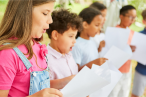 A group of children singing together at a casual performance.